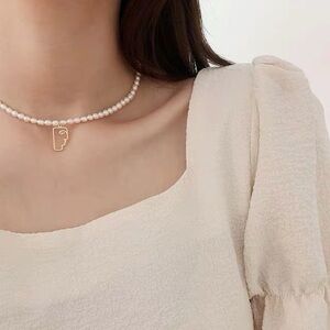 Abstract face pearl necklace